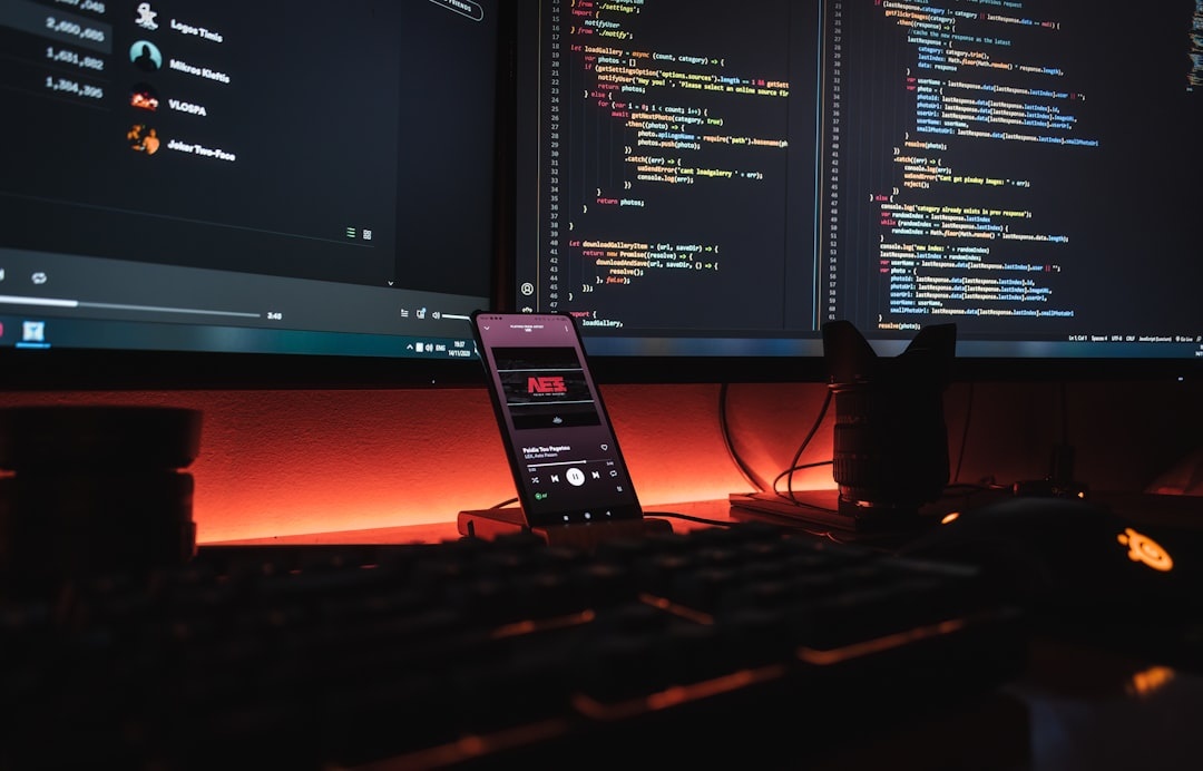 Software engineer writing code on dual monitors in a modern office