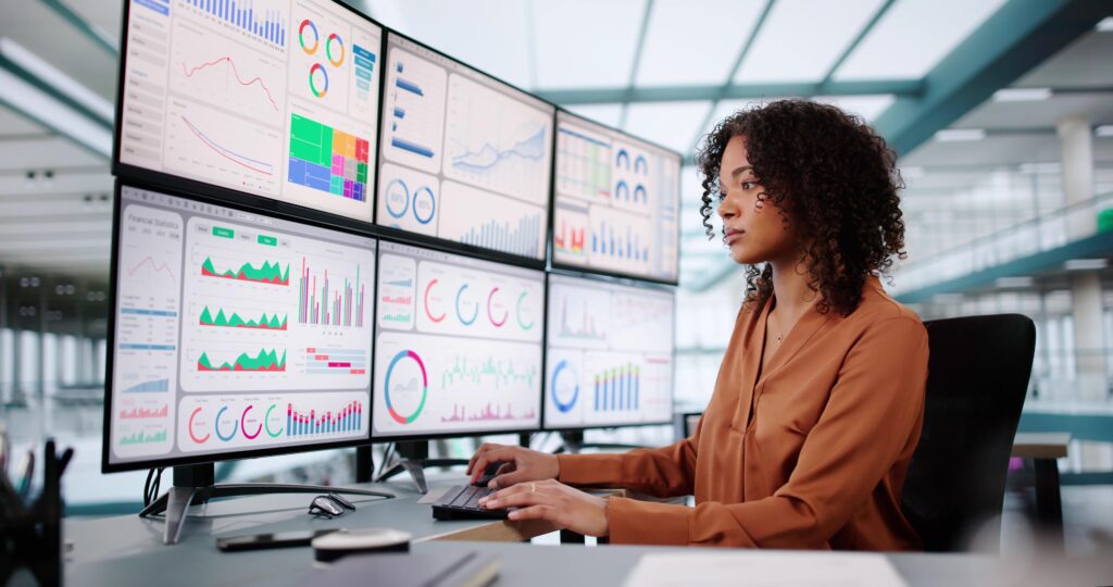 Business analyst comparing business metrics across multiple analytics dashboards