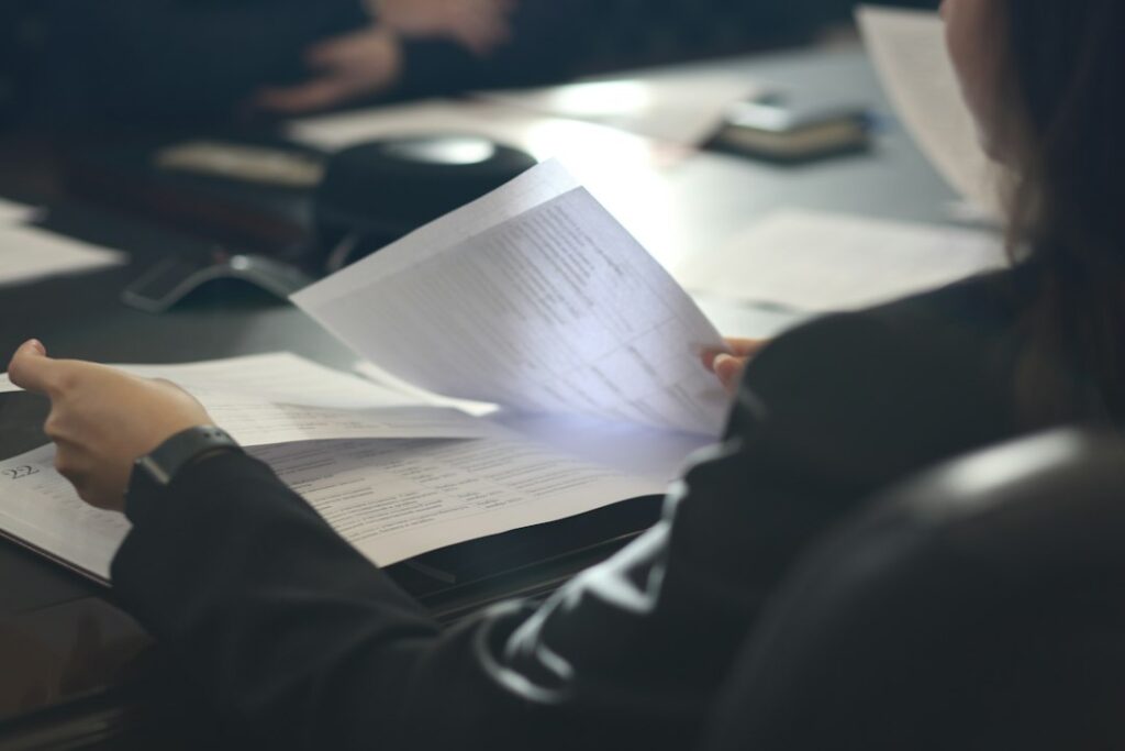 Business professional reviewing documents at a desk representing human in the loop approval workflows for ai agents.